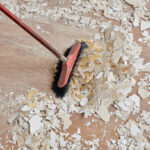 Builder sweeping the floor after renovation